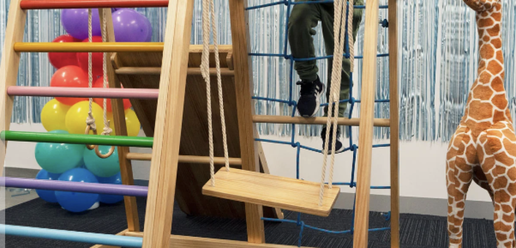 Photo of a boy smiling while playing with his kinder gym