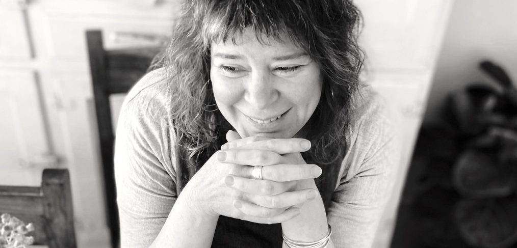 black and white photo of a woman sitting down smiling